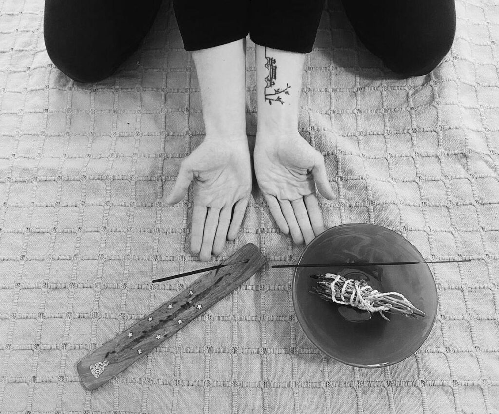 praticienne à genou paume ouverte vers le ciel encens